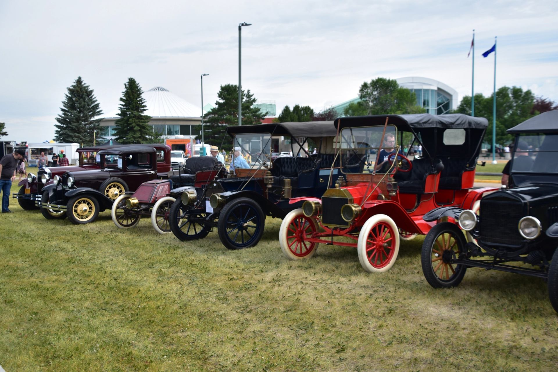 Vintage early‑20th‑century cars lined up outdoors.