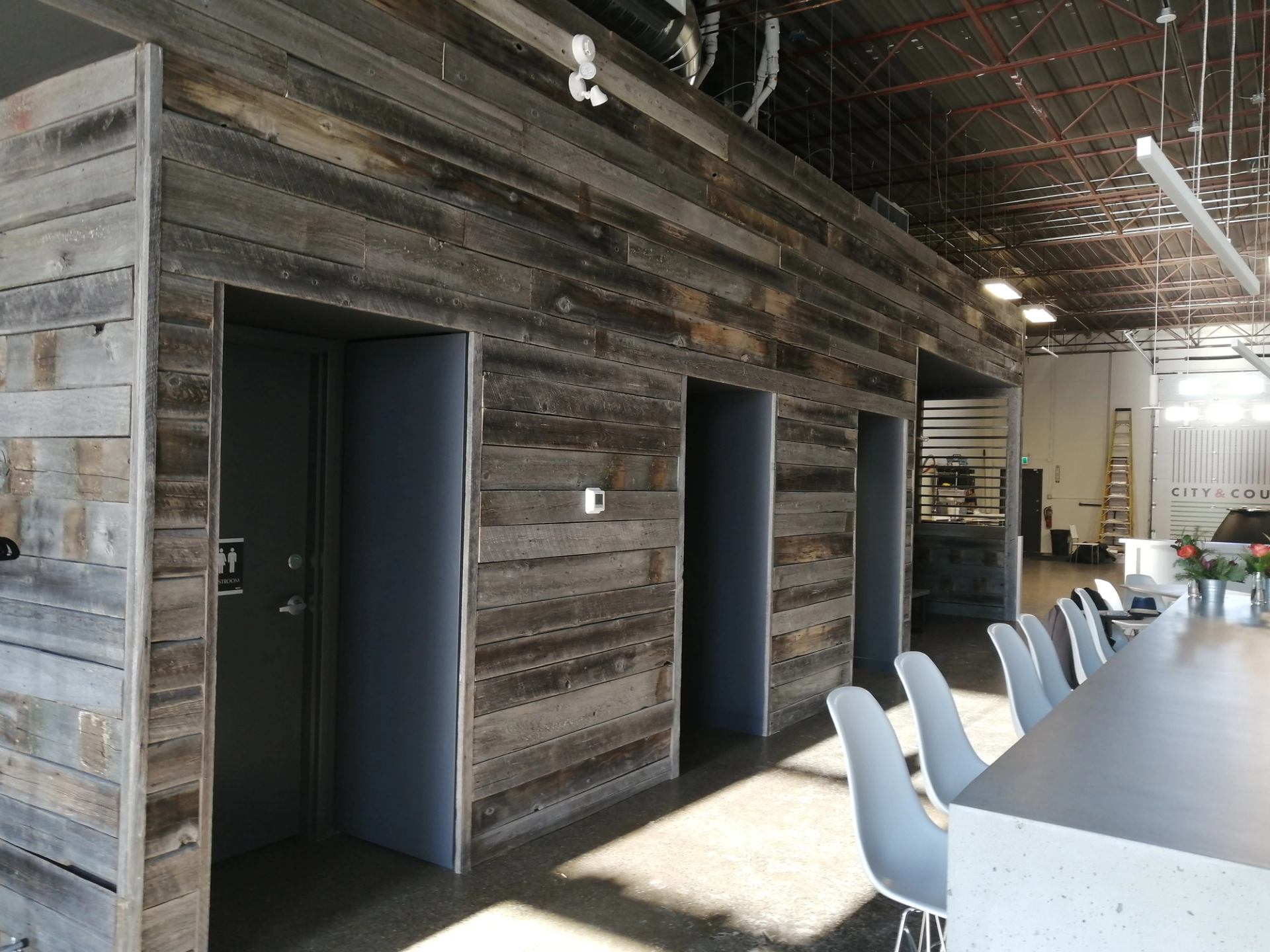 Rustic tasting room at City & Country Urban Winery with wood walls and bar seating.