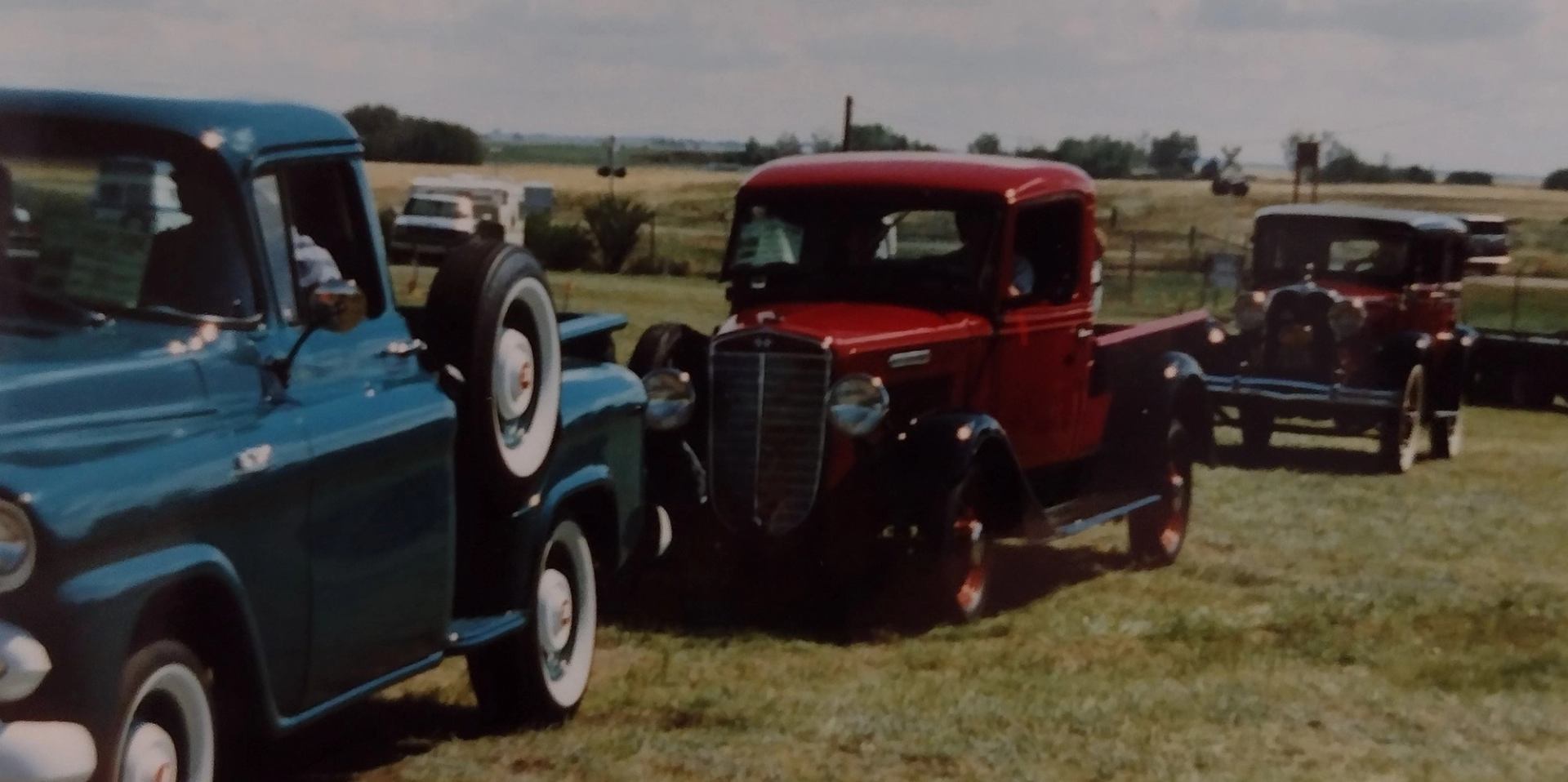 Classic cars in a field.