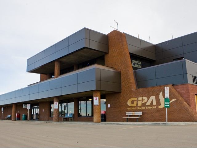 Grande Prairie Airport terminal exterior with GPA sign on brick and glass facade.