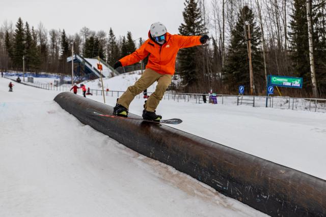 A snowboarder does a trick while snowboarding at Nitewhawk Adventure Park in Grande Prairie