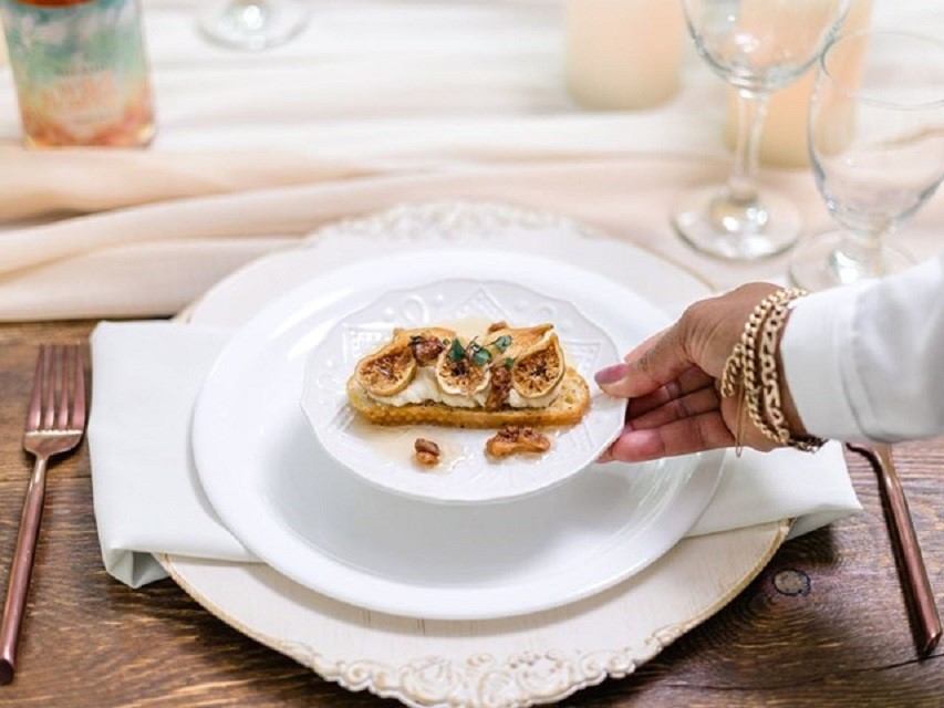 Elegant table setting with plated appetizer and wine glasses in soft focus.
