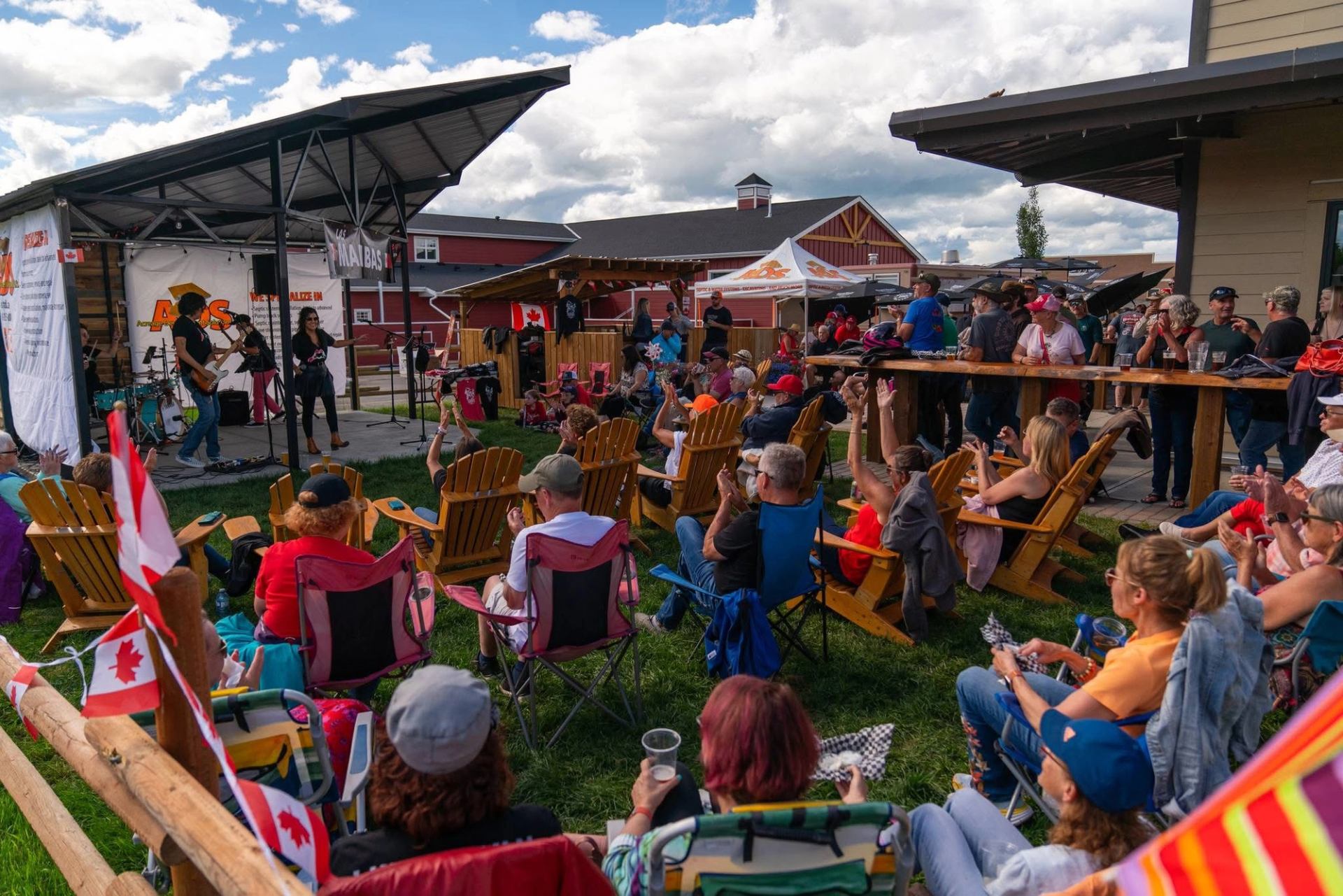 Crowd seated outdoors watching a live band perform at Hard Knox™ Brewery on a summer day.