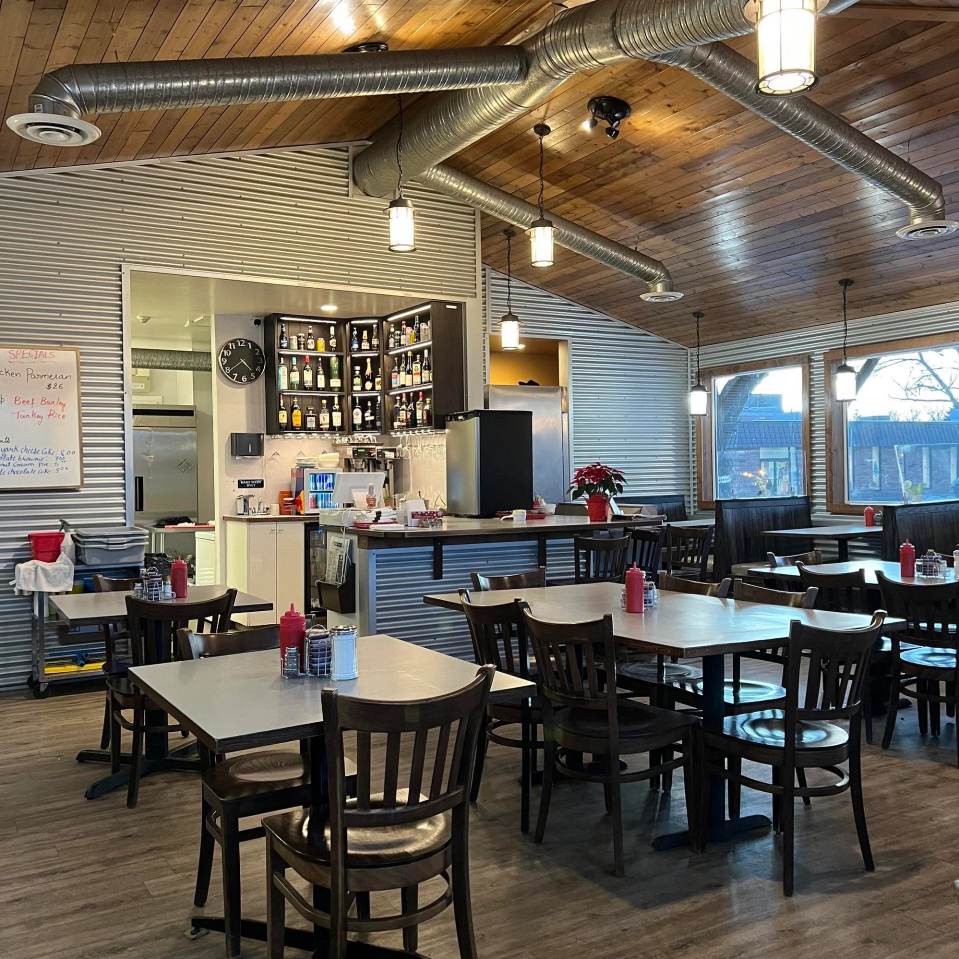 Southfork Restaurant interior with tables, bar area, and wood-paneled ceiling