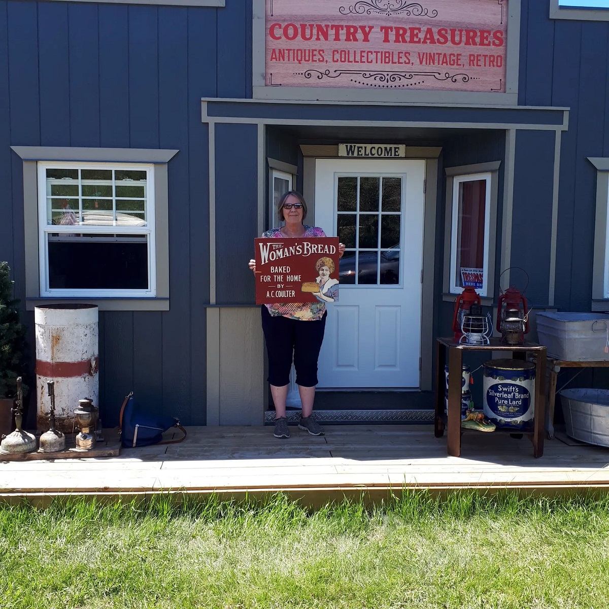 Country Treasures storefront with fresh bread sign, rustic decor, red chairs, and vintage charm.