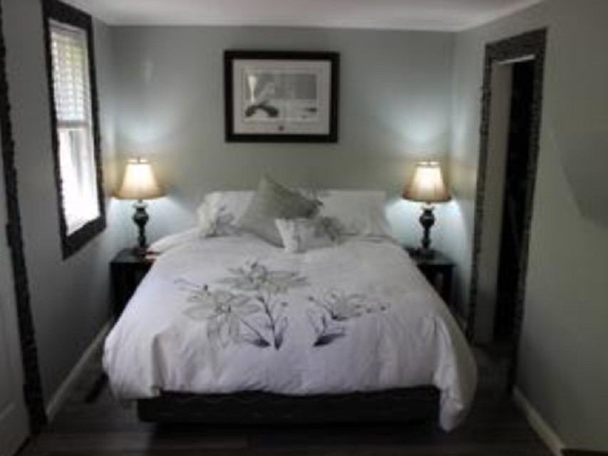 Cozy bedroom with queen bed and two lamps at River Shack accommodations.