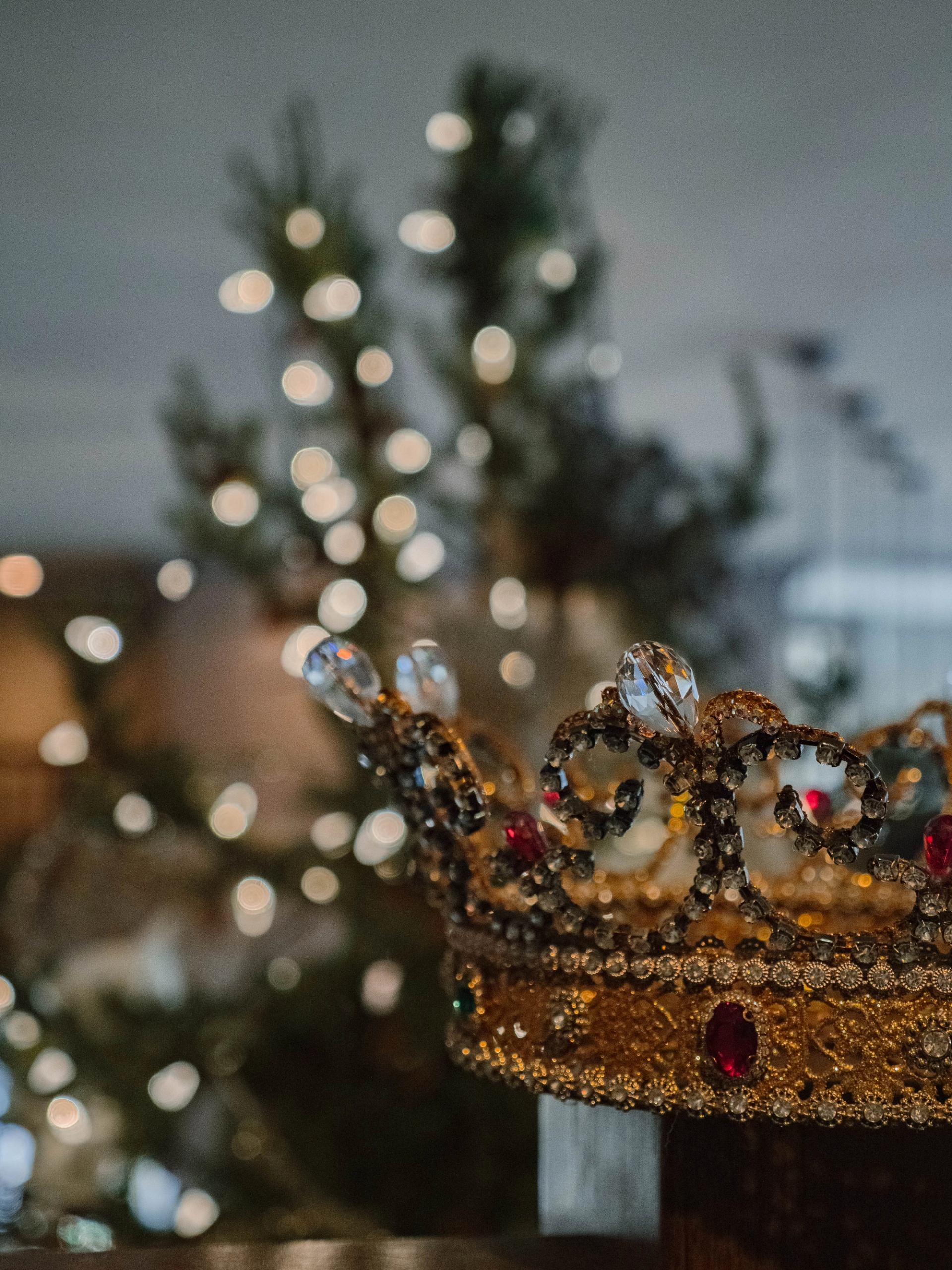 Decorative crown in front of a blurred Christmas tree with lights at The Malcolm Hotel.