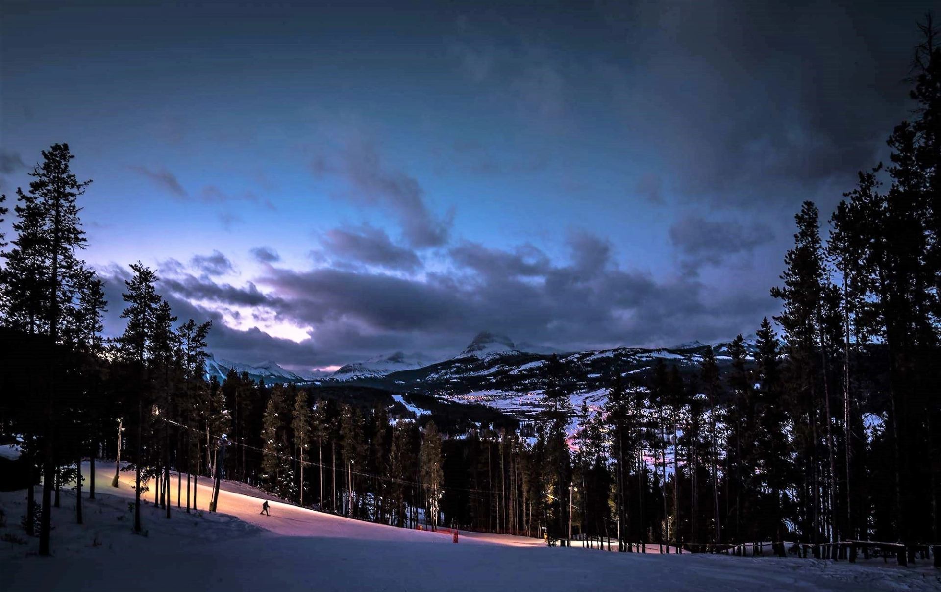 Twilight turns to magic at Pass Powderkeg—groomed runs, glowing skies, and a peaceful alpine evening on the slopes.
