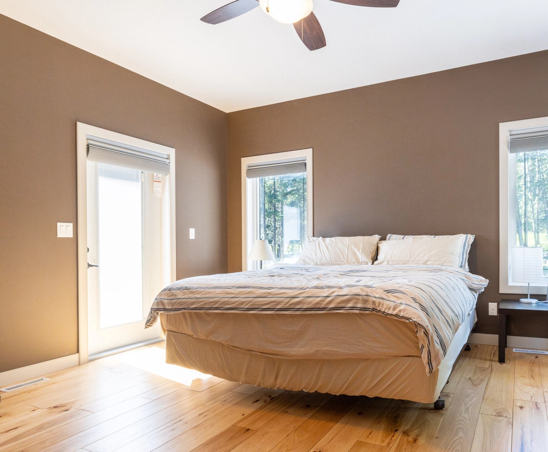 Cozy bedroom with white bedding and wood floors.