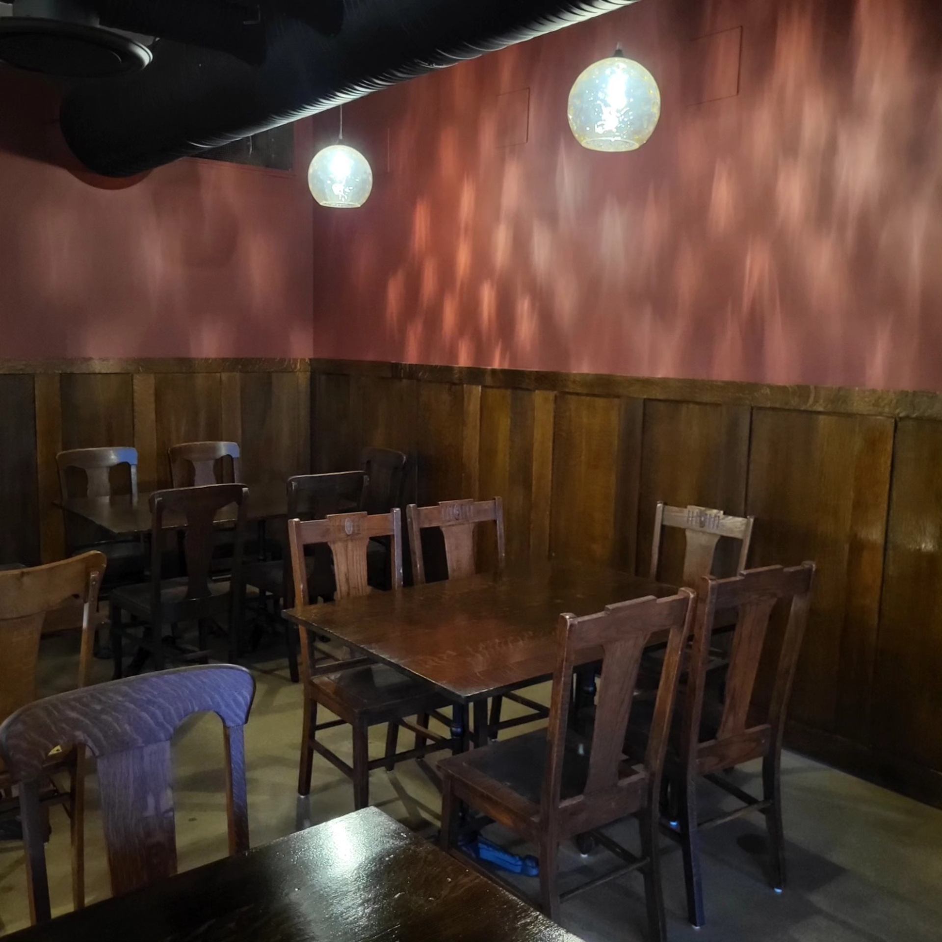 Cozy wooden tables and chairs in a warmly lit corner.