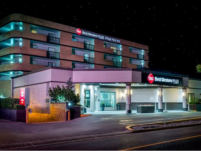 Best Western Plus Village Park Inn exterior with lit entrance and signage at night.