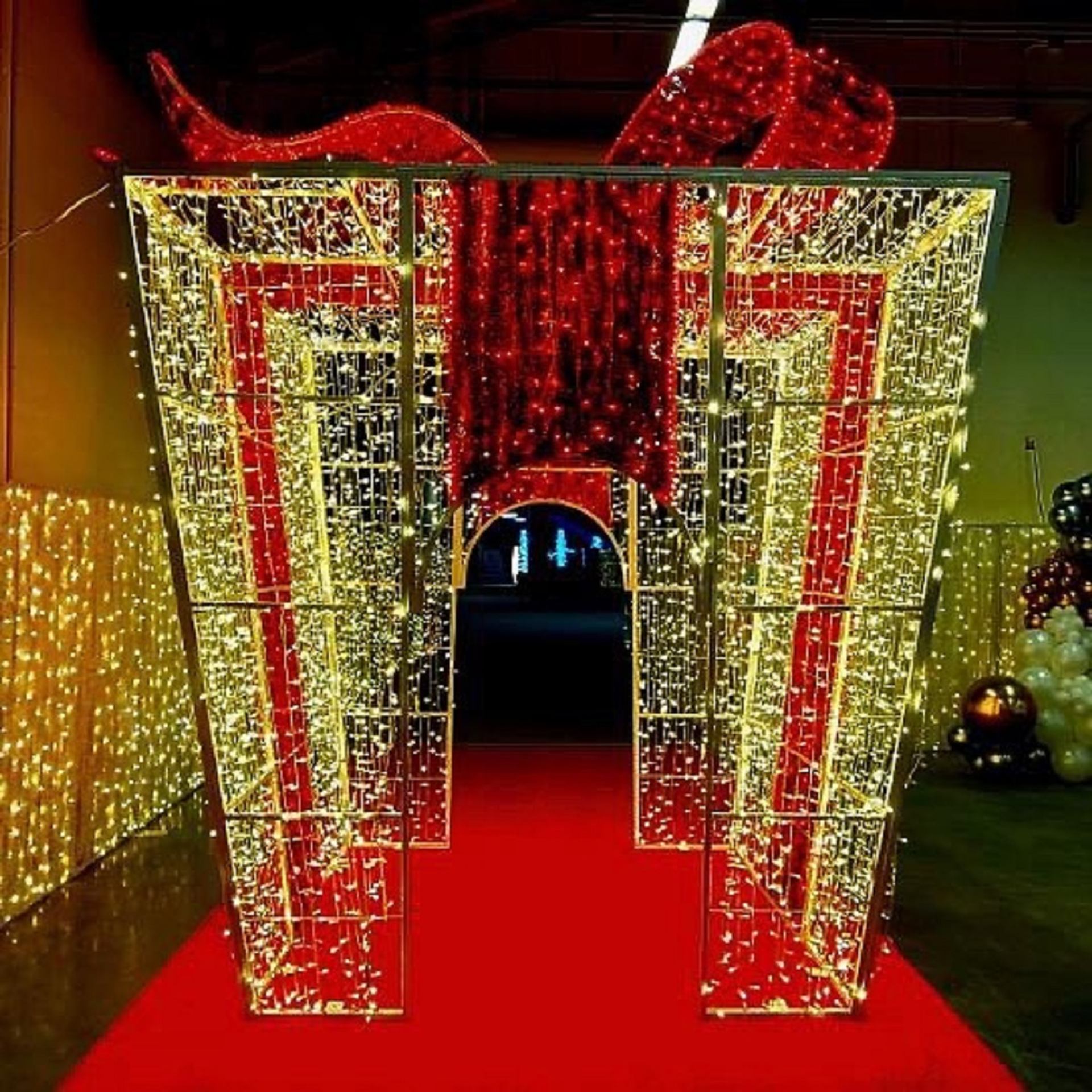 Illuminated red and gold archway with festive lights at Glow Calgary.