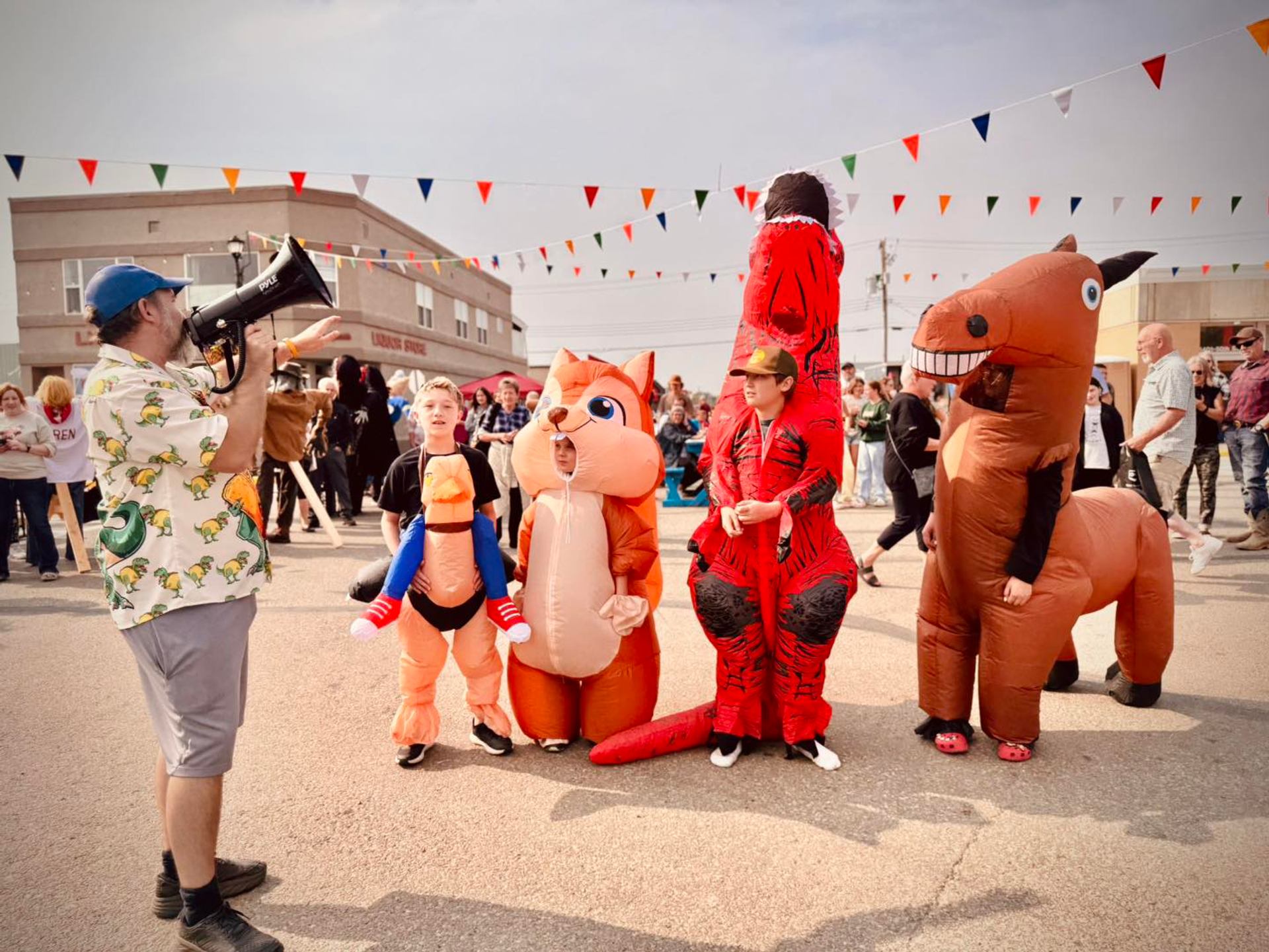 Festival performers in inflatable costumes stand on a closed street during the Harvest Moon Festival.