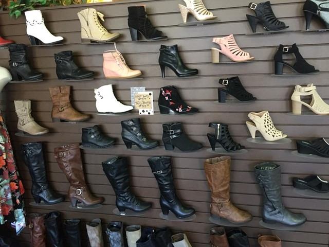 Shoes displayed on wall shelves, including boots and high heels in various colours.