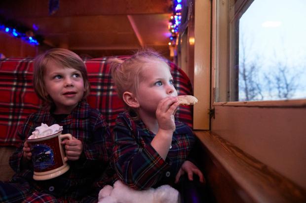 Children aboard the Polar Express eating cookies and drinking hot chocolate