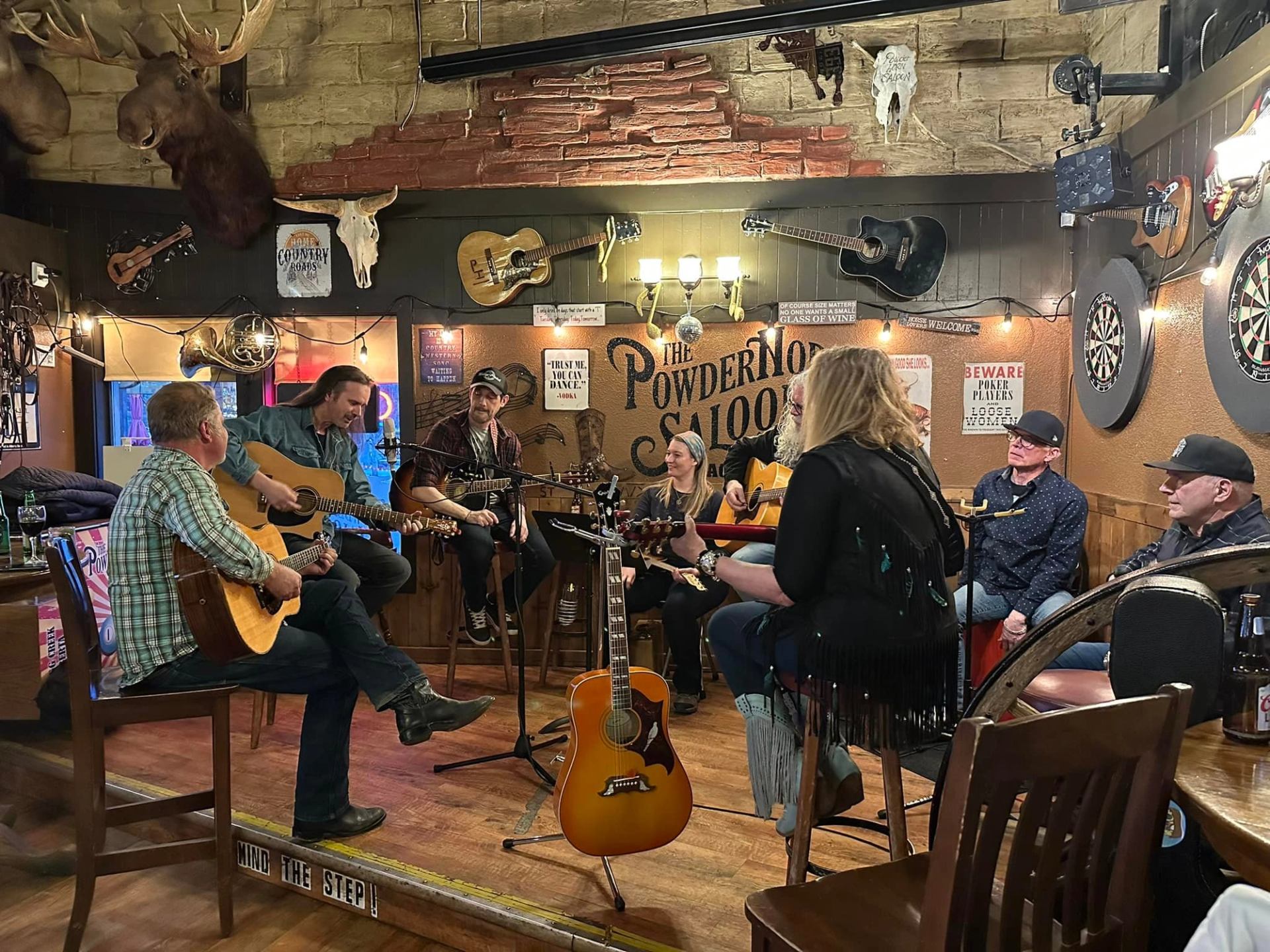 Musicians with guitars gathered for a jam session at Powderhorn Saloon.