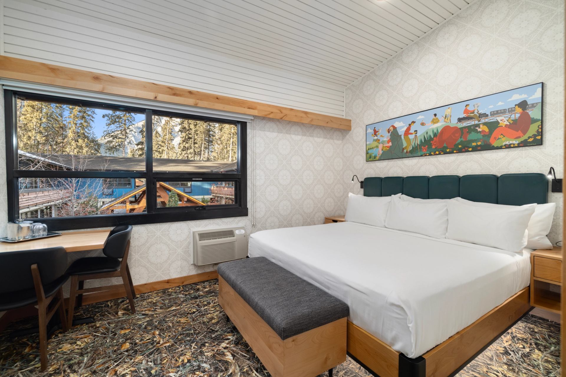 Modern motel room with green headboard, white bedding, and colorful wall art.