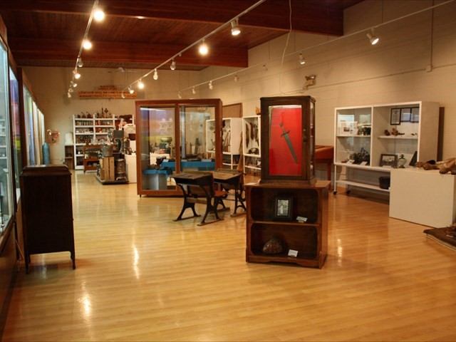 Museum interior with display cases, artifacts, and visitor seating.
