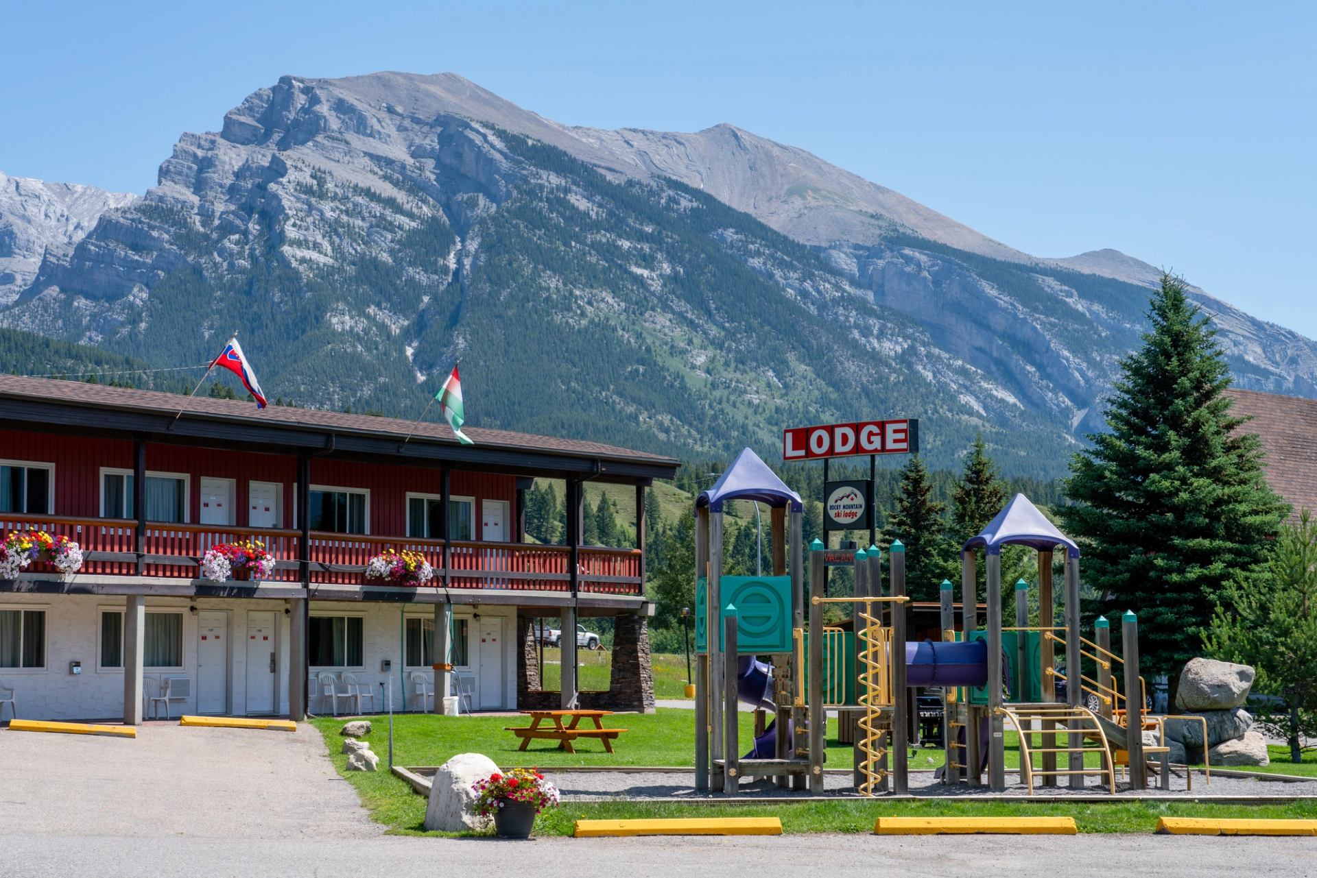 Rocky Mountain Ski Lodge with playground and mountain backdrop.