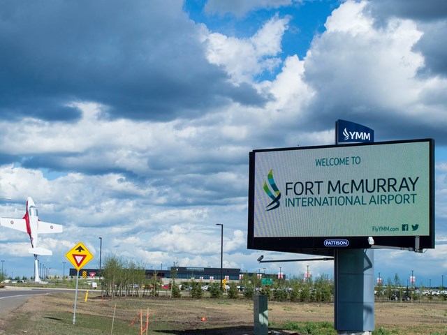 Digital welcome sign with plane and buildings at Fort McMurray International Airport.