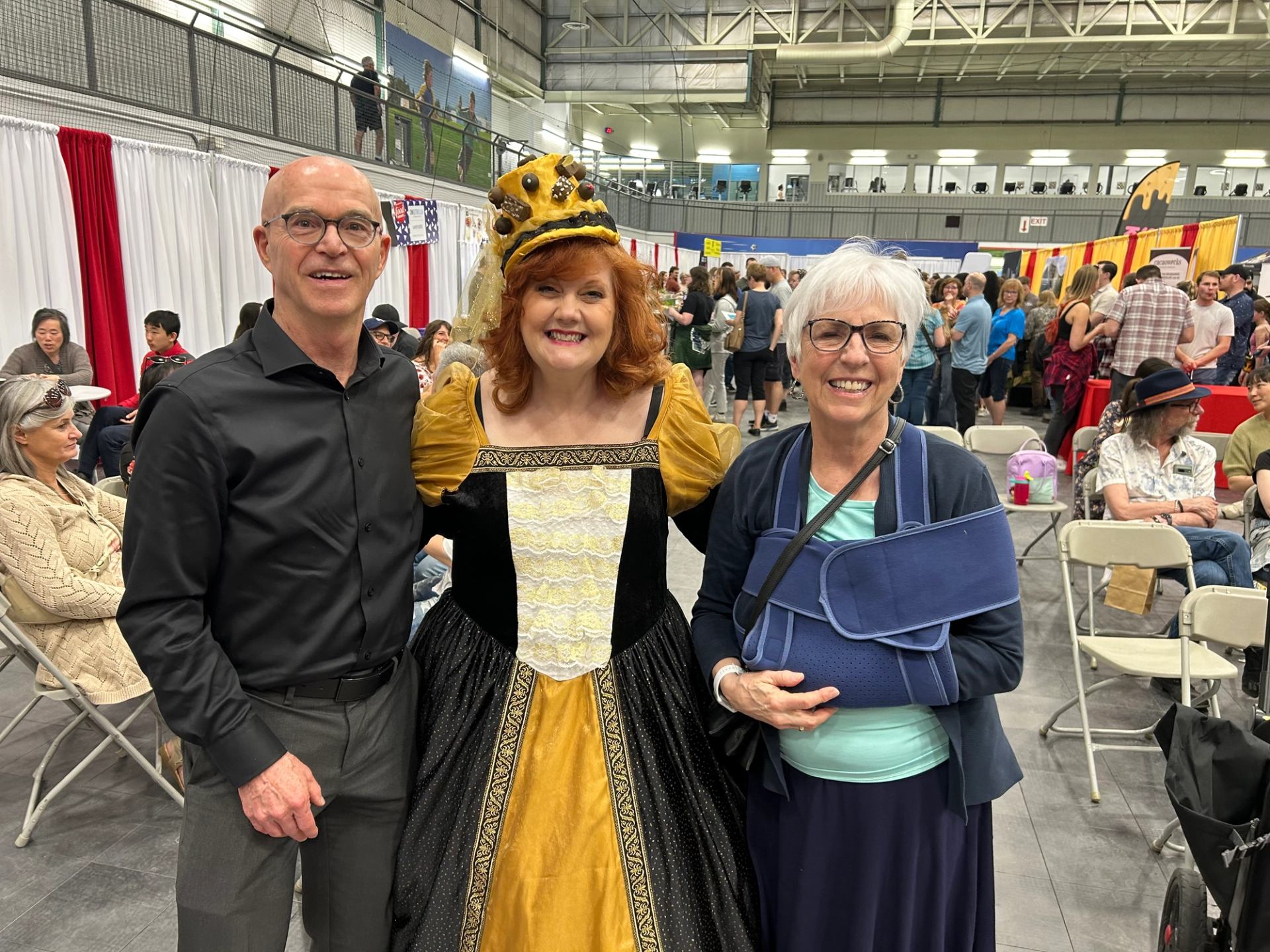Three people standing at ChocoFest, one wearing a gold and black costume.