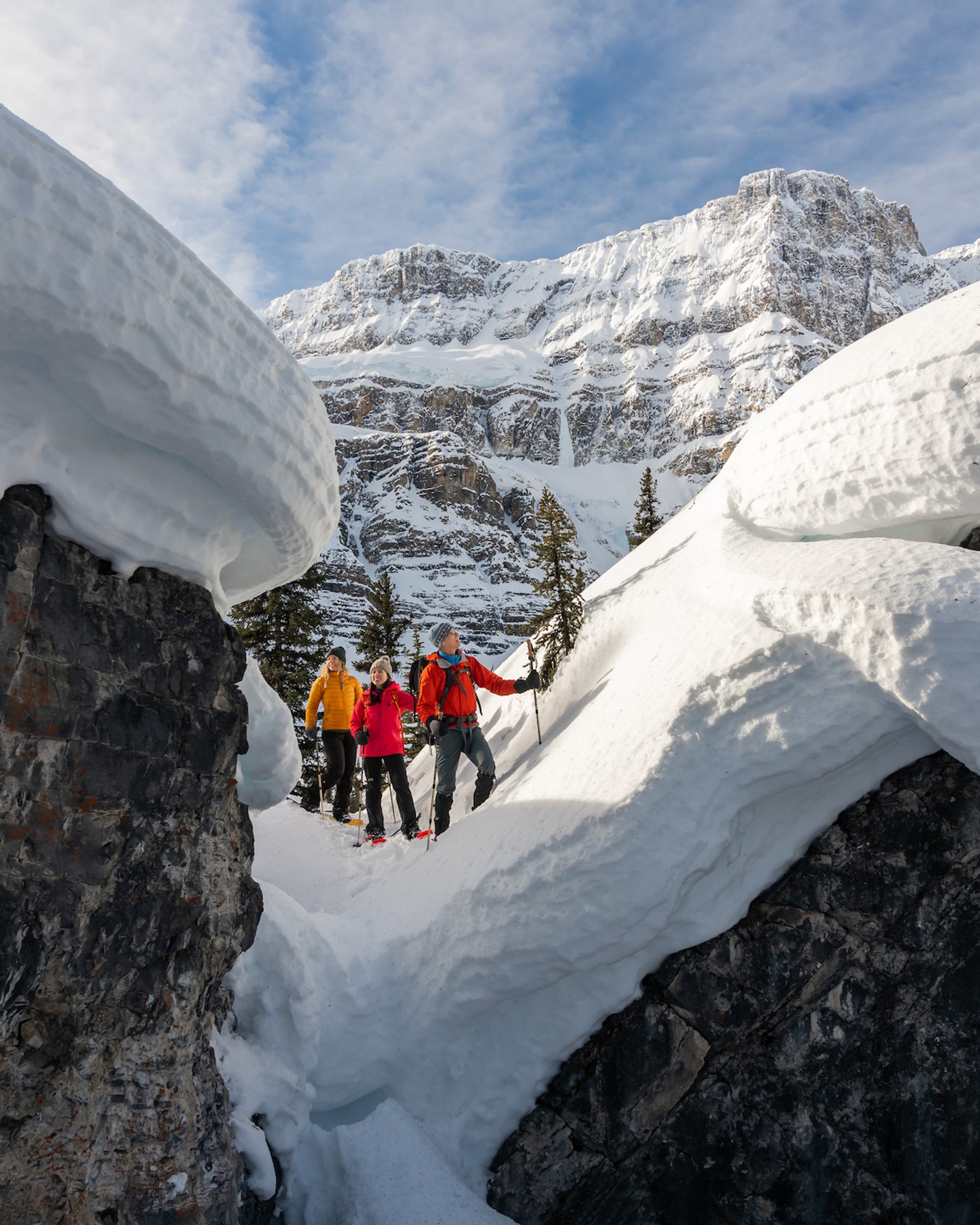Snowshoers admiring "snow mushrooms," large pillows of snow on top of rocks.