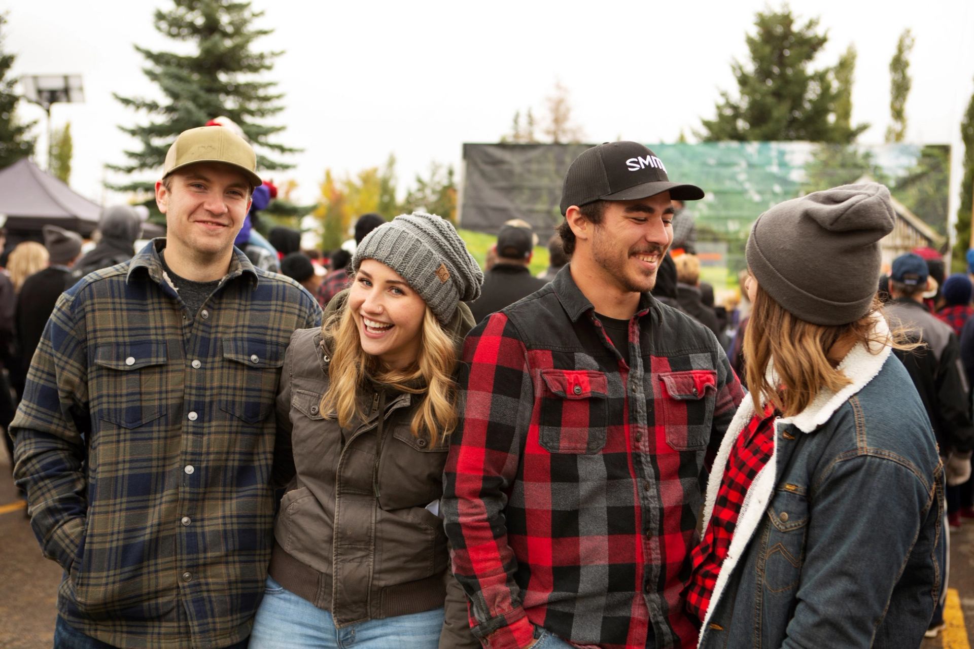 Group of friends enjoying Flannel and Feast outdoors in cozy fall attire.