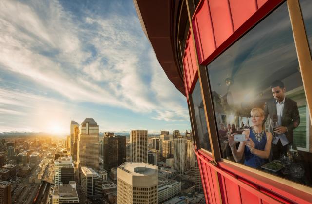 Couple having dinner at Sky 360 Restaurant with views of the city skyline from the Calgary Tower.