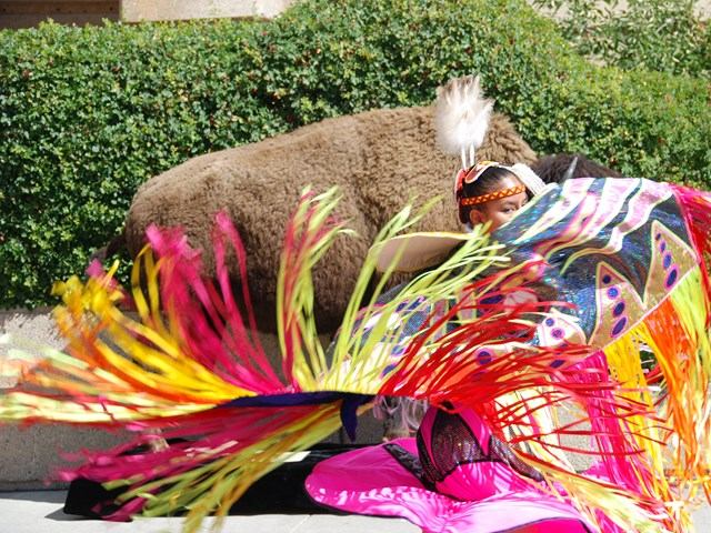 Plaza performer in festive costume with feathered details.