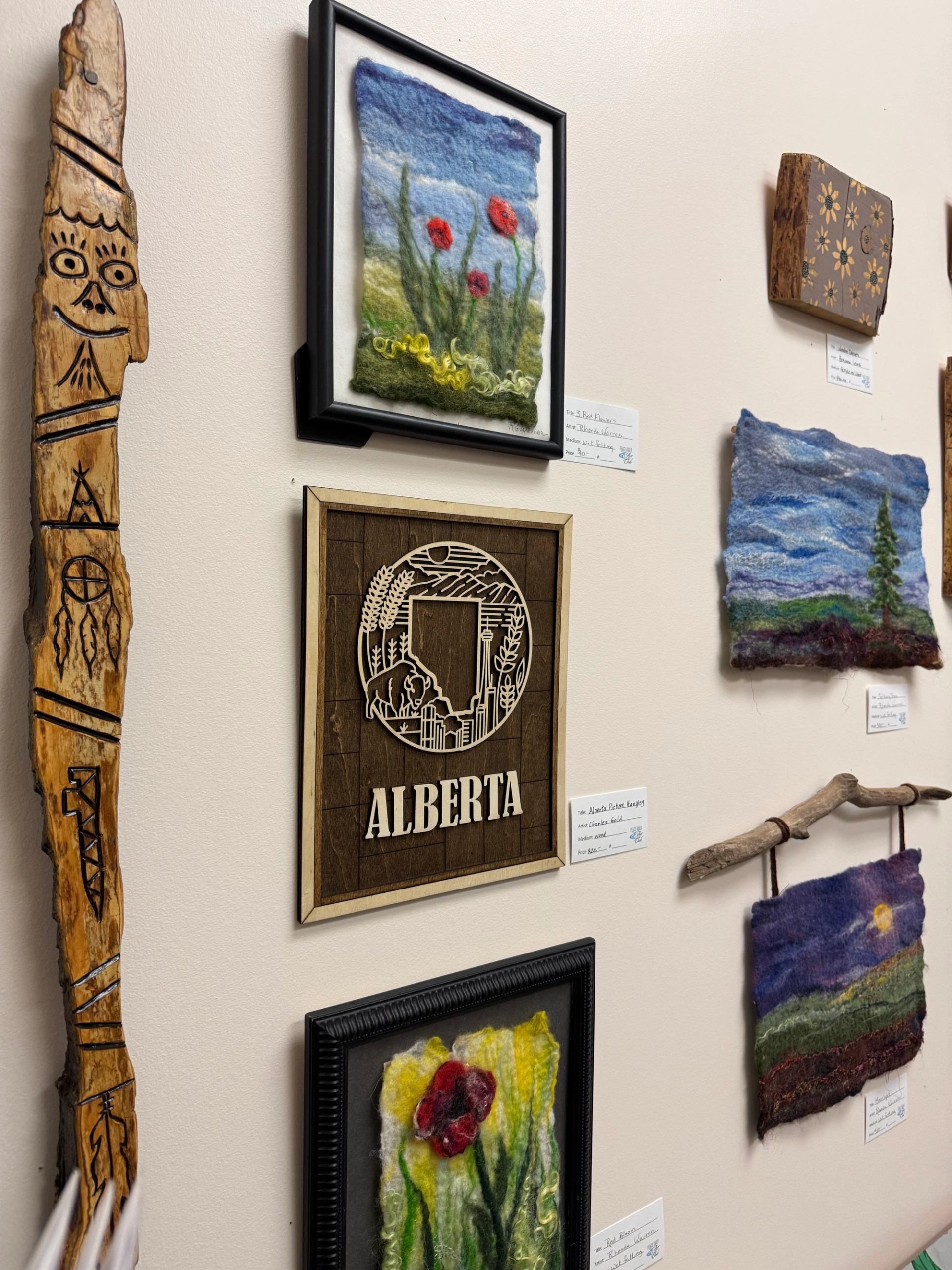 Mixed media art and crafts displayed on wall at Peace River Art Club.