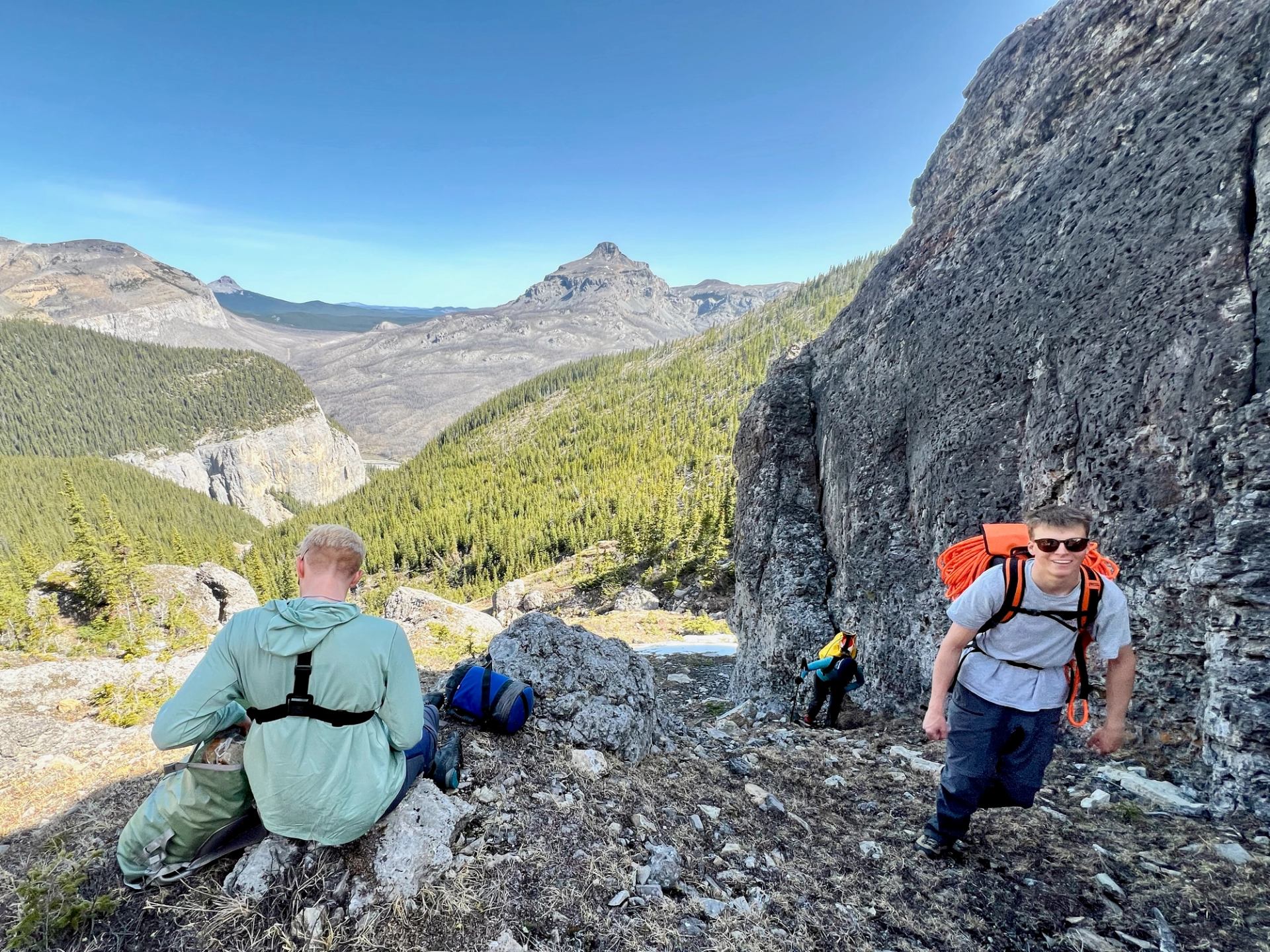 Group hiking along rocky cliffs with mountain views in Bow Valley.