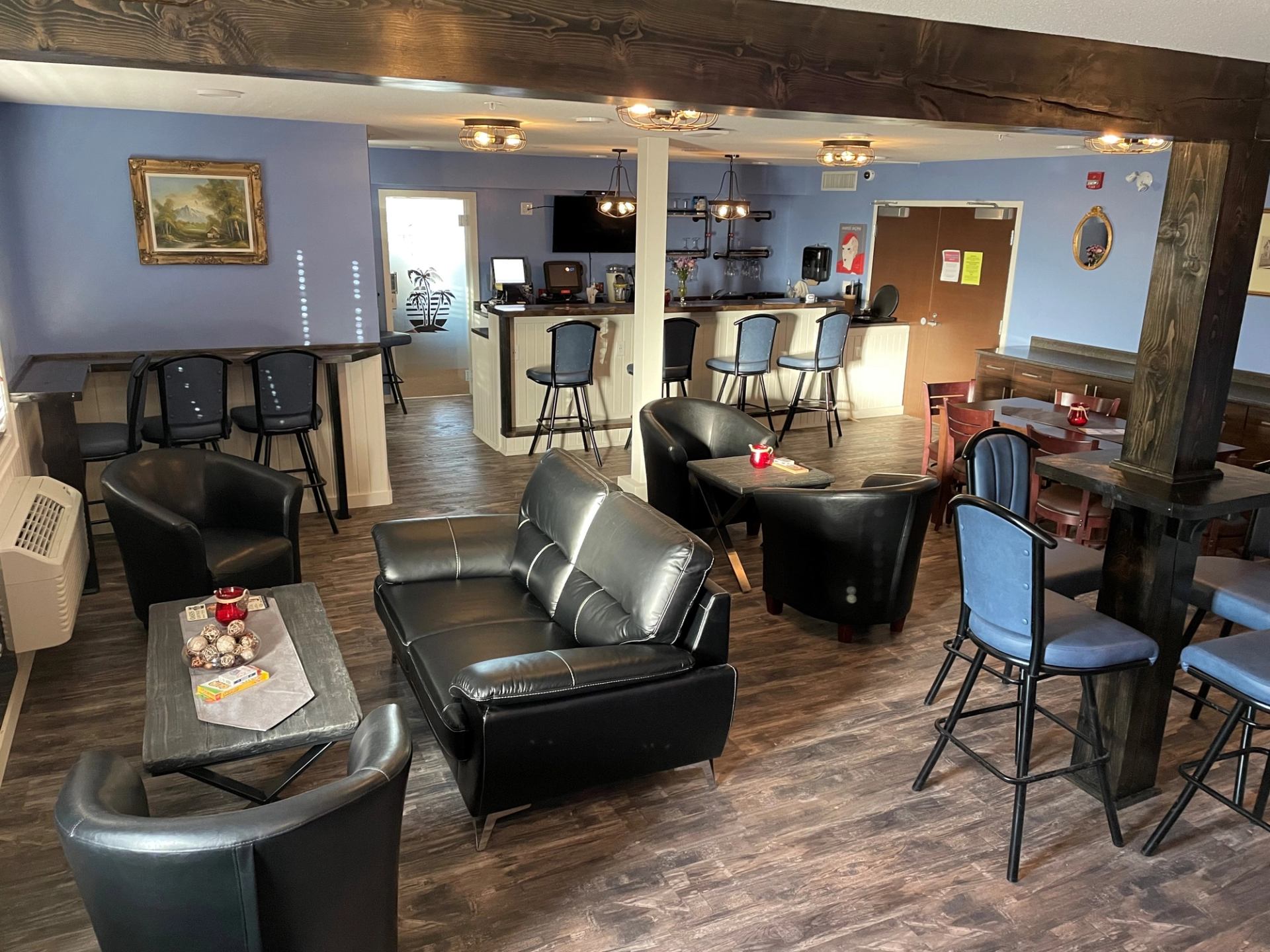 Travelodge lounge with leather seating, tables, and bar area.