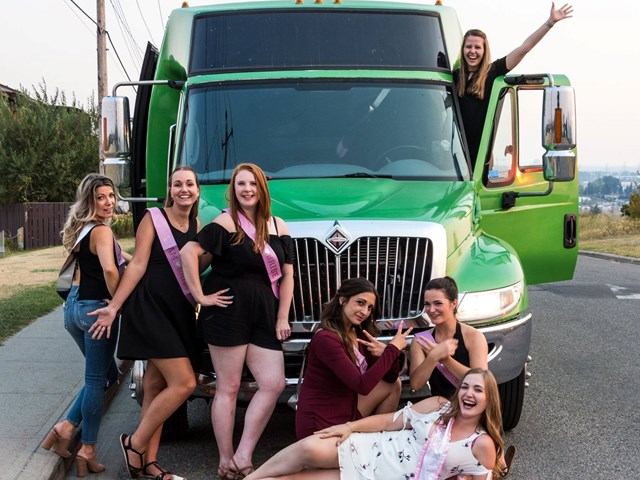 Group posing in front of green party truck with one person standing in the open door.