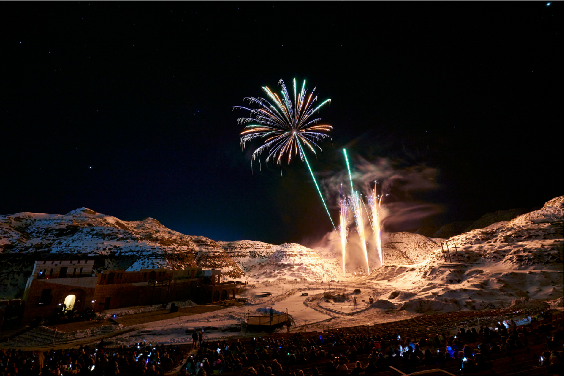 Green fireworks explode above the hills of the Badlands Amphitheatre 