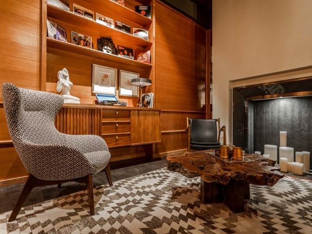 Stylish lounge with patterned chairs, wood shelving, and cozy decor.