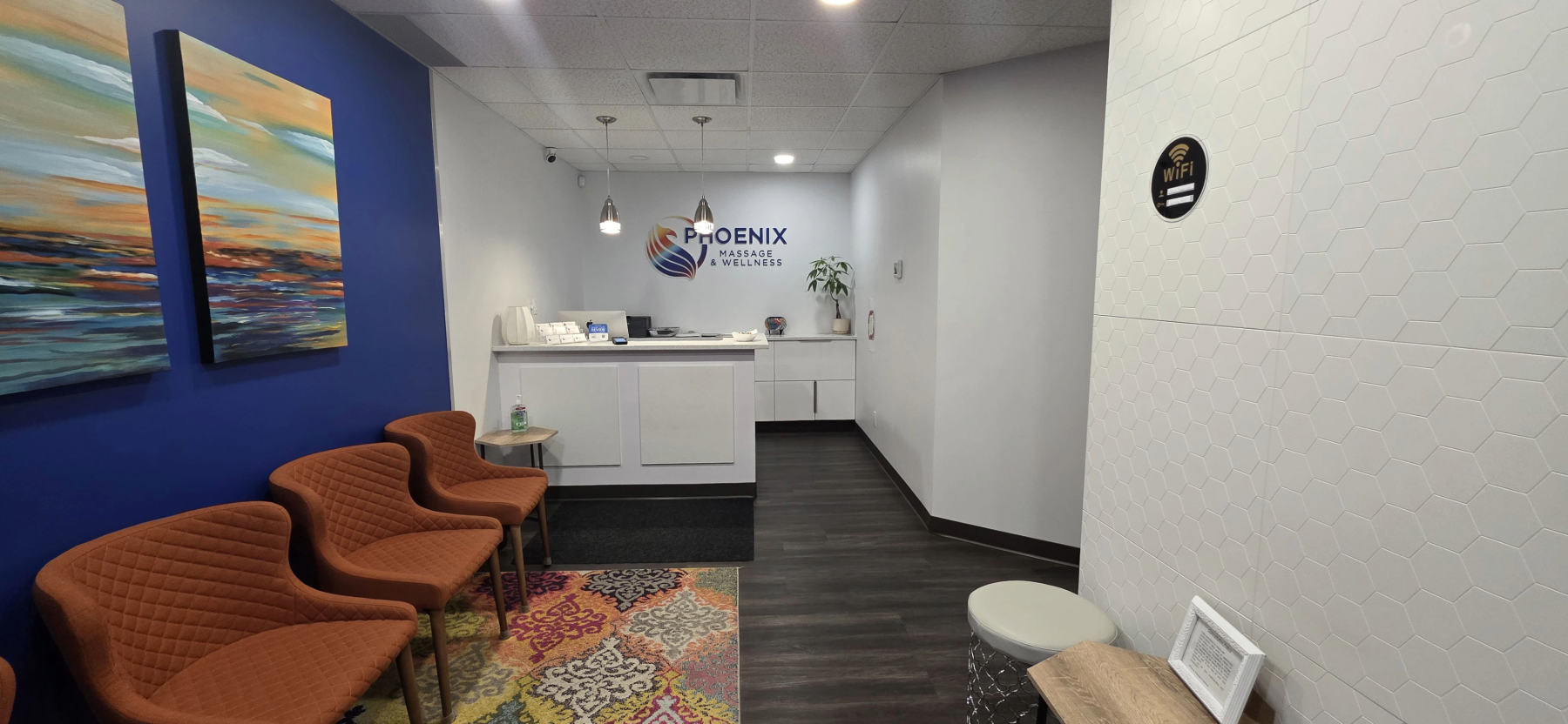Phoenix Massage and Wellness reception area with chairs, artwork and a patterned rug.