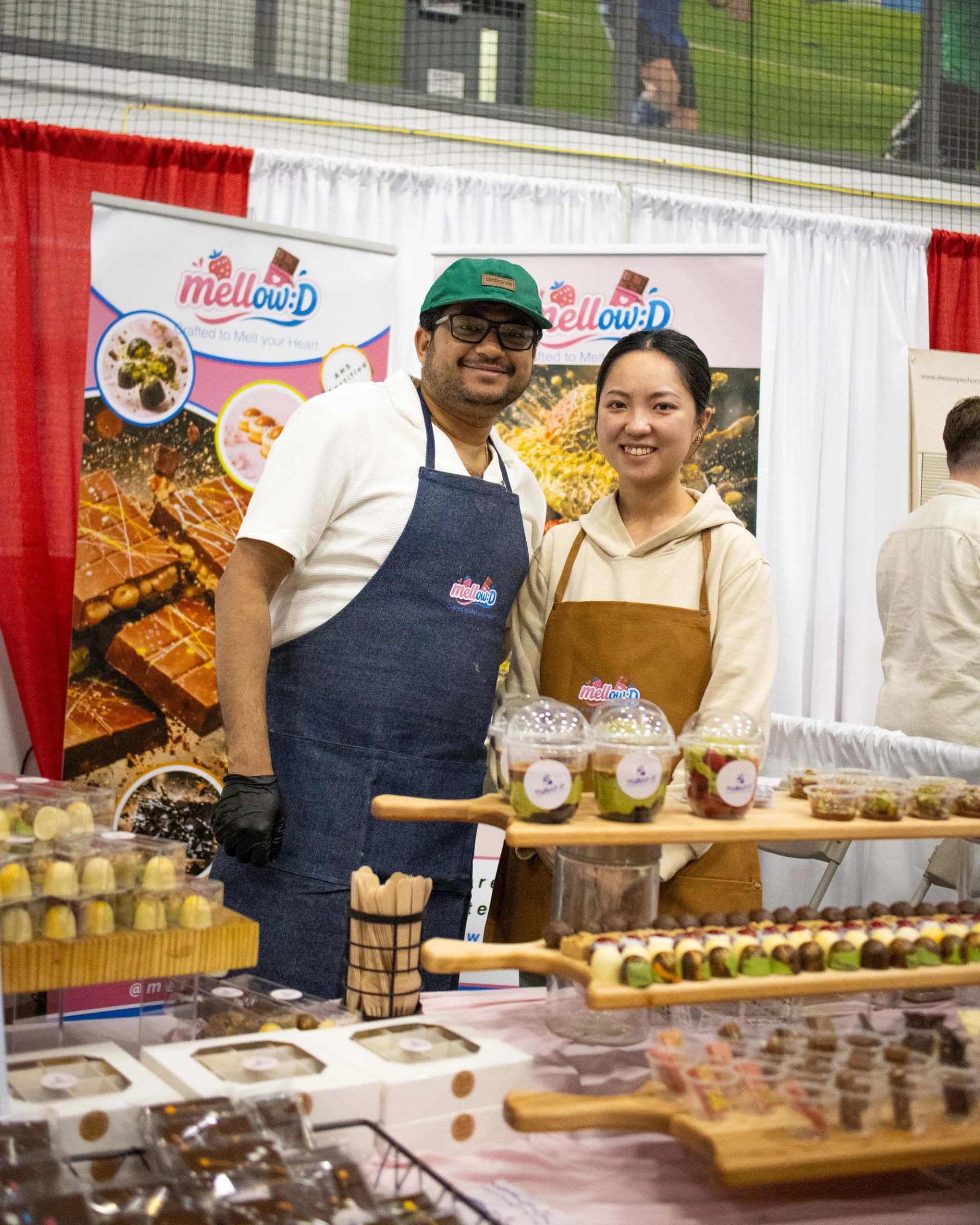 Chocolate maker stands at his booth at ChocoFest with an assortment of delicious chocolates.