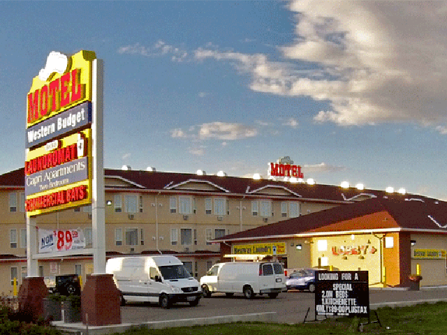 Exterior of Western Budget Motel Ponoka with parking lot, sign, and several parked vehicles.