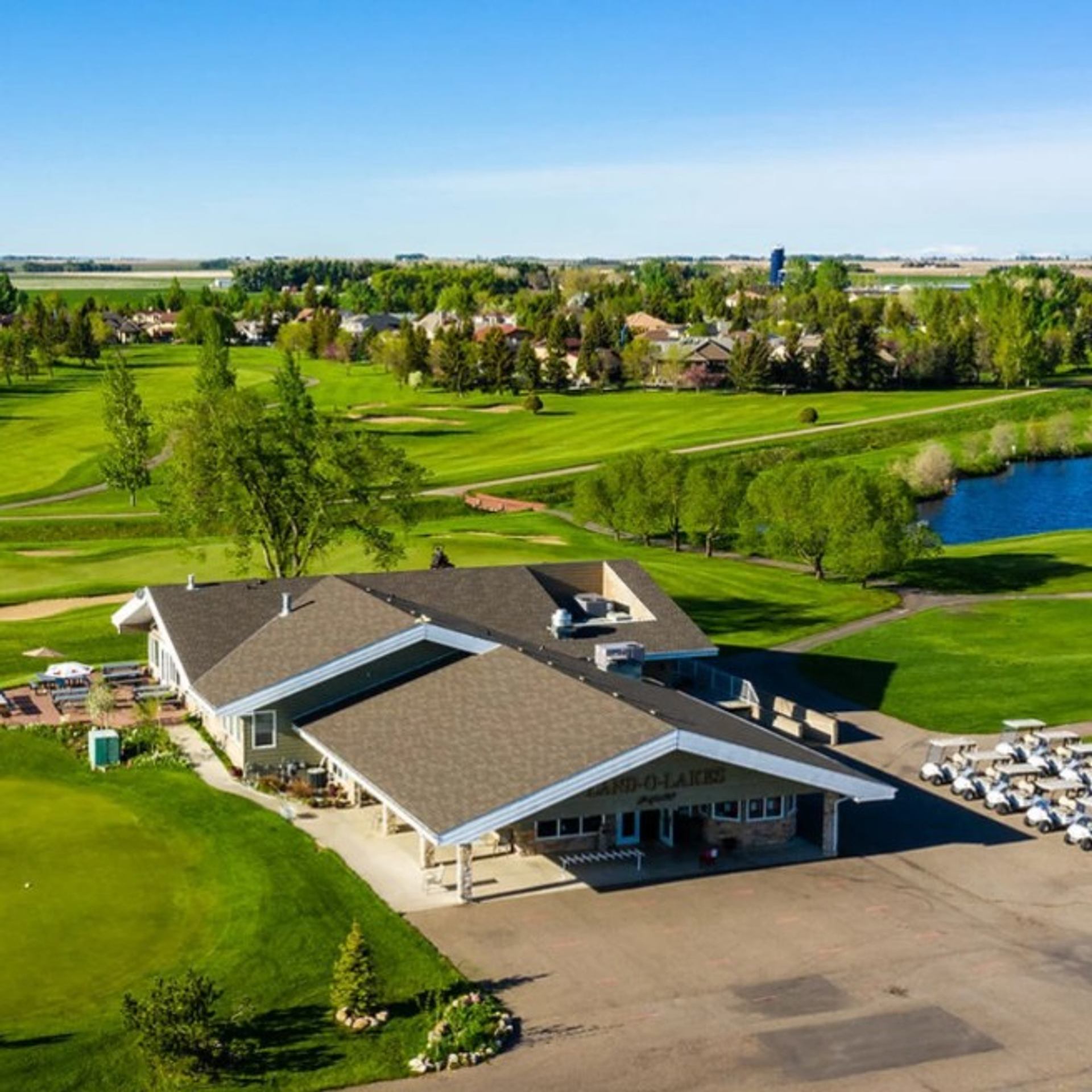 Aerial view of clubhouse with golf carts and green fairways in the background