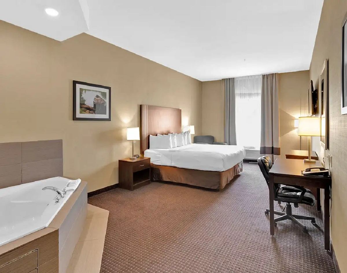 Hotel room with a king bed, desk, and in-room whirlpool tub.