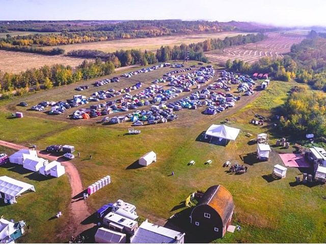 Bird’s-eye view of tents, vehicles, and trees at Métis Crossing Campground.