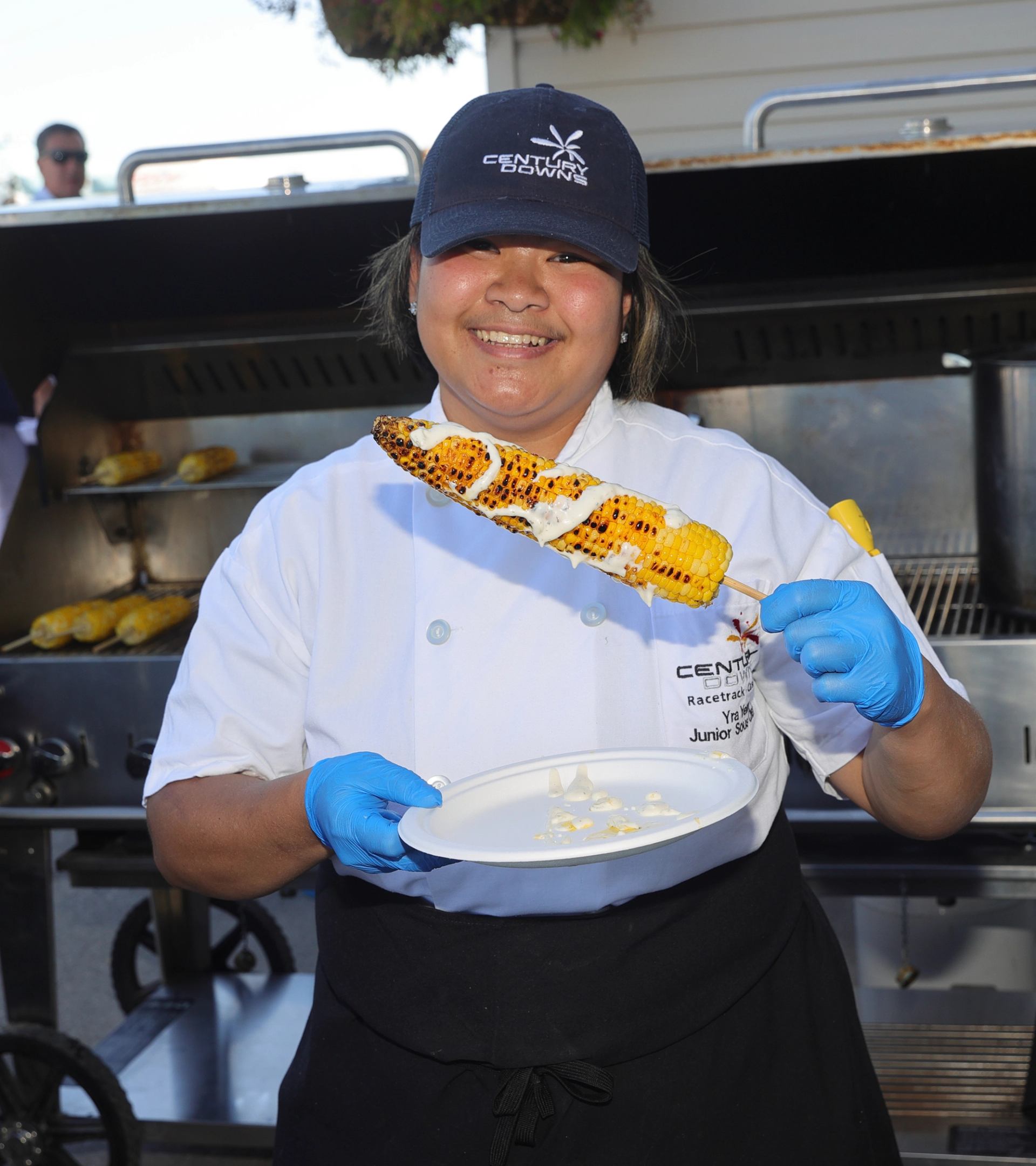 Chef holds plate with grilled corn at Cornstock