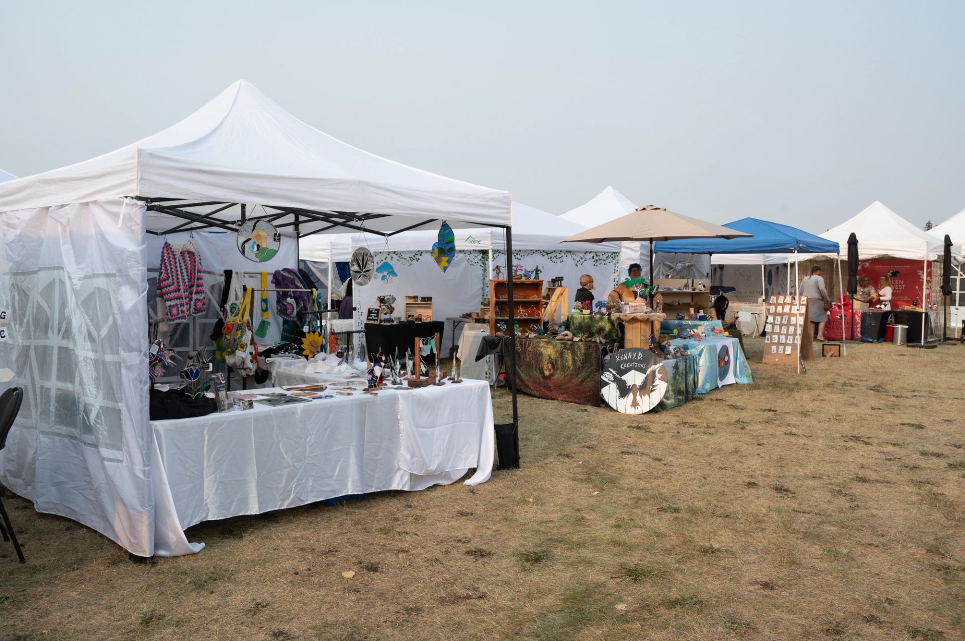 Artisan vendor tents displaying handmade goods at an outdoor market.