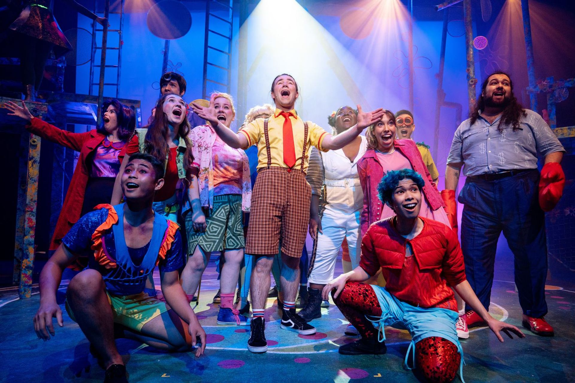 Cast performs SpongeBob-themed musical at Storybook Theatre with vibrant lighting.