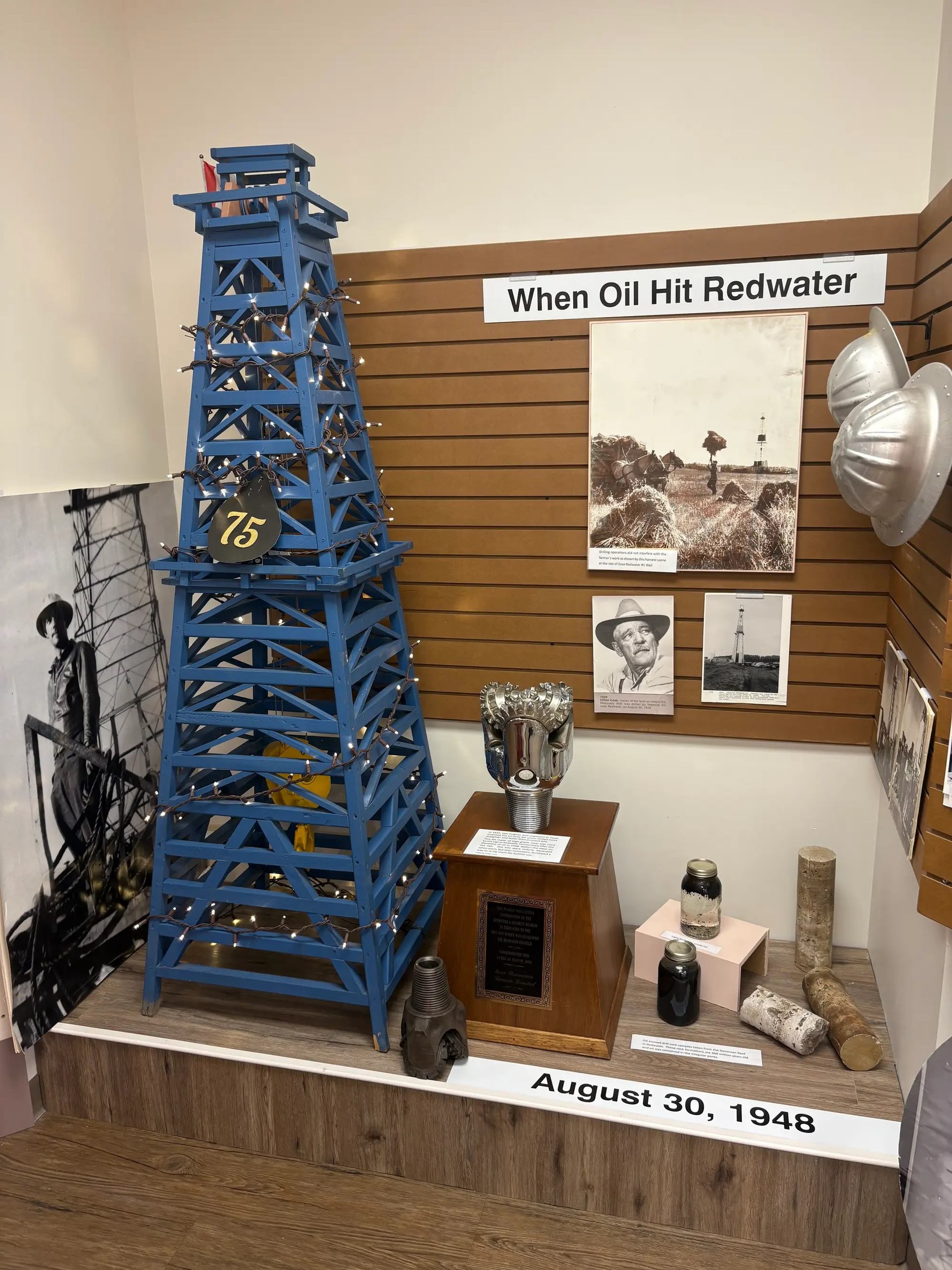 Display of oil derrick replica, drill bit & oil sample.