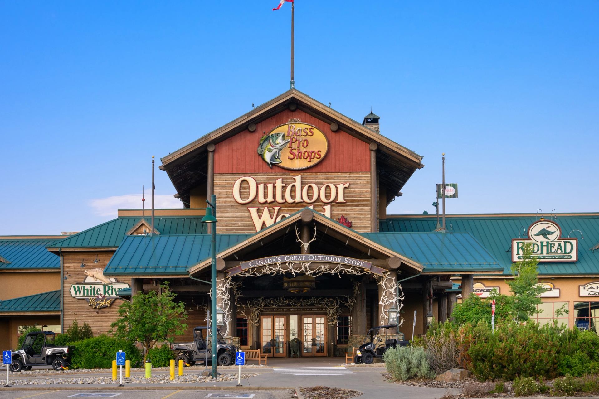Rustic Bass Pro Shops exterior with antler arch and green roof at CrossIron Mills.