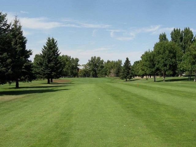 Lush fairway lined with trees under a partly cloudy sky at Connaught Golf Club.