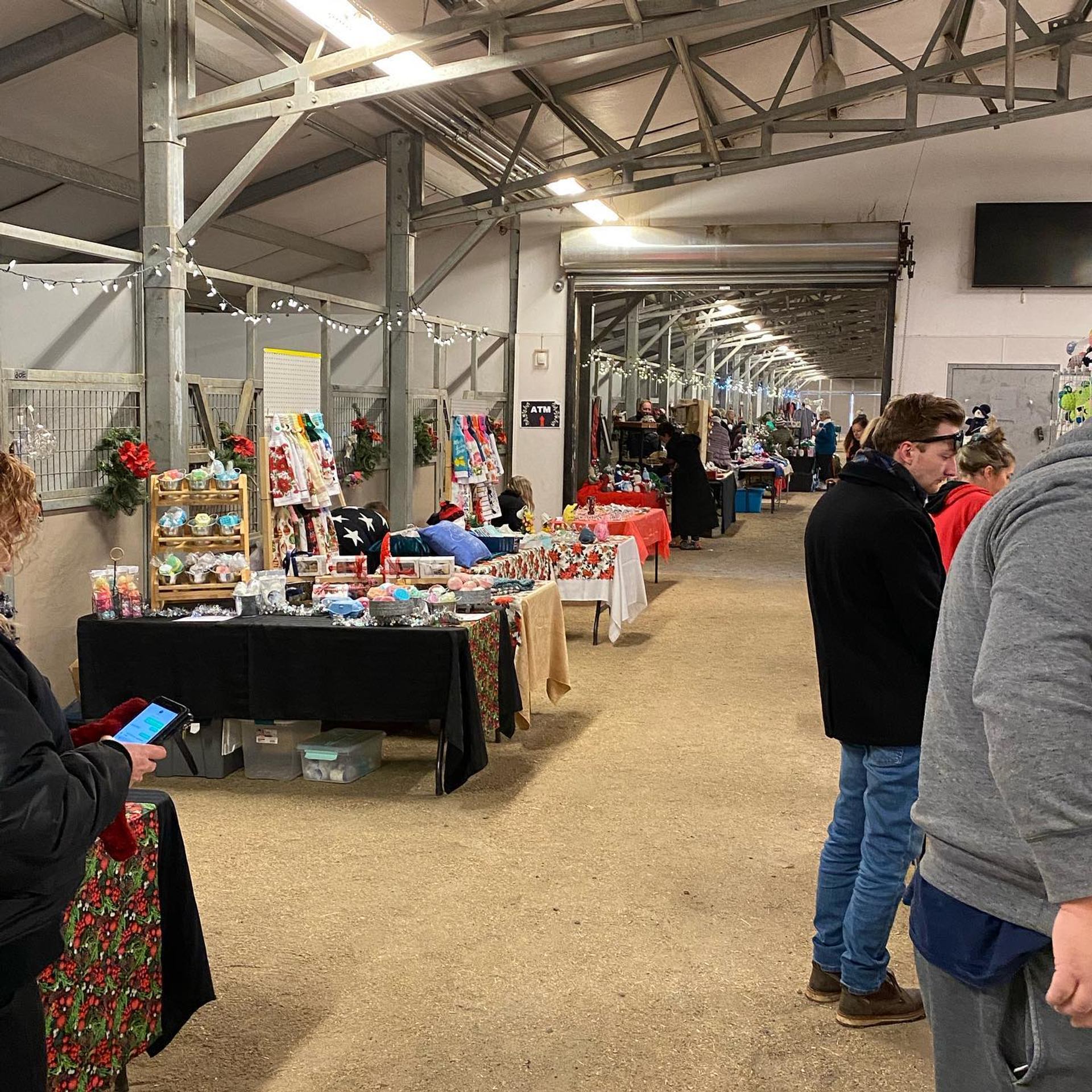 People browsing vendor tables at an indoor craft fair