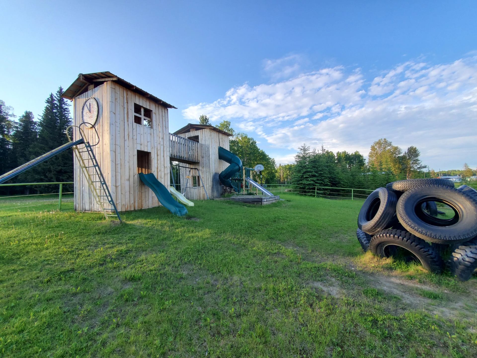 Wooden playground with slides and tire climber at Medicine Lodge Campground.