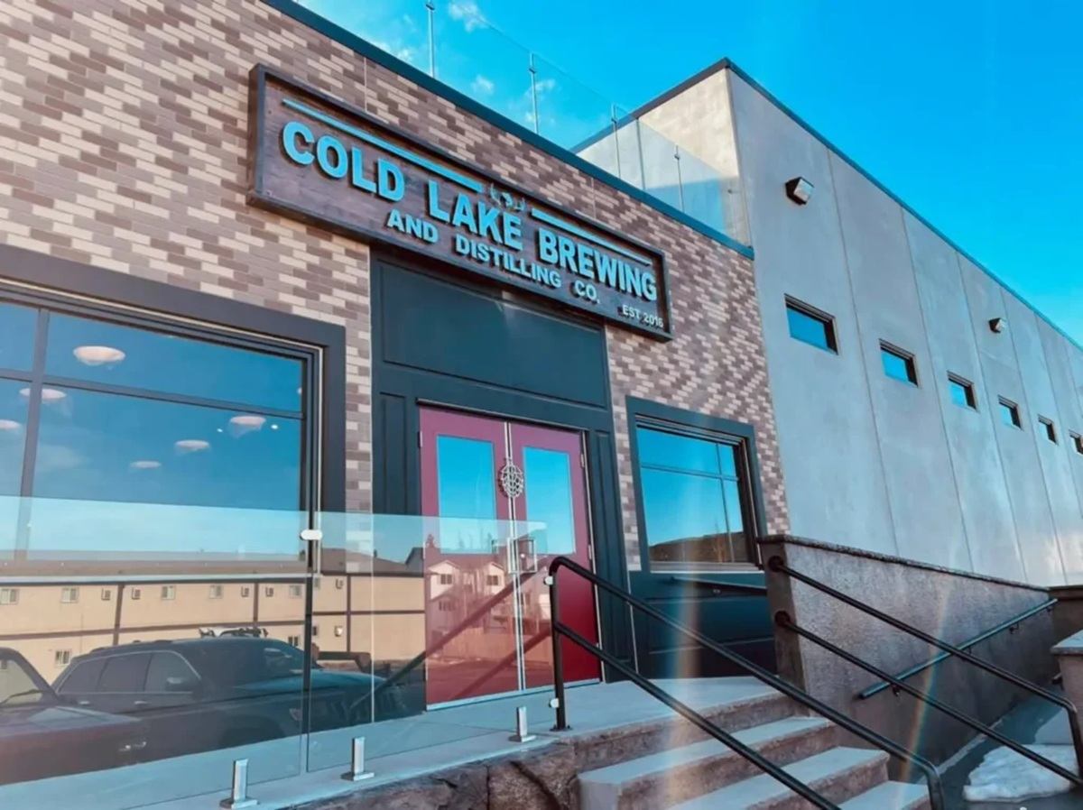 Cold Lake Brewing and Distilling Co. exterior with red doors and glass-railed stairs.